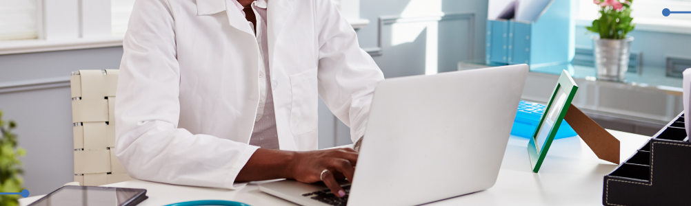 A female health care professional typing on her work laptop.